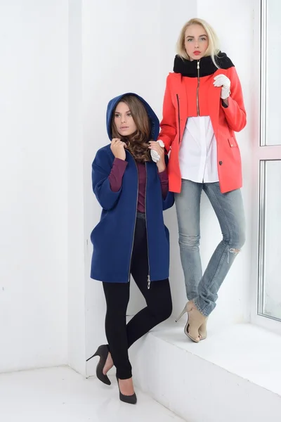 Girls in studio posing at coats — Stock Photo, Image
