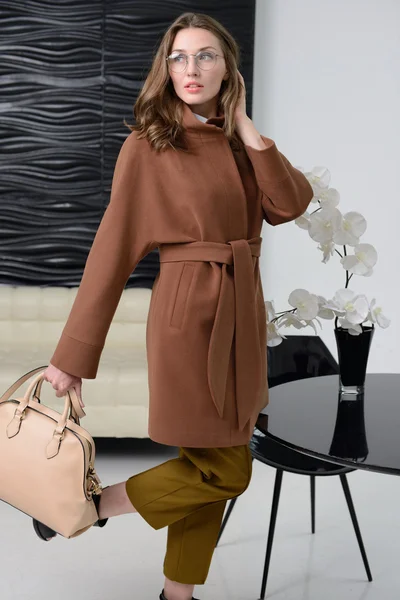 Girl in studio posing at coat — Stock Photo, Image