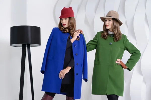 Girls in studio posing at coats — Stock Photo, Image