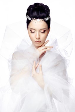 Young woman with closed eyes isolated on white studio background dressed in the cape of organza and beautiful tiara clipart