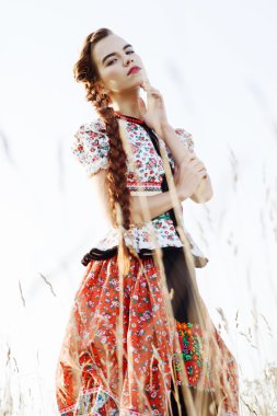 Macar Ulusal Kostüm giymiş genç köylü kadın, doğa arka plan üzerinde poz