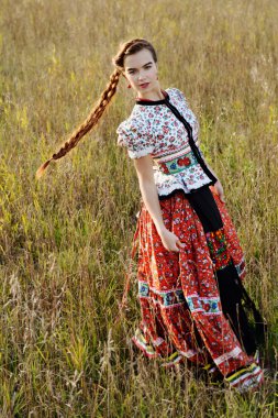 Macar Ulusal Kostüm giymiş genç köylü kadın, doğa arka plan üzerinde poz