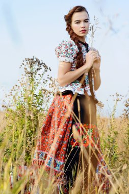 Macar Ulusal Kostüm giymiş genç köylü kadın, doğa arka plan üzerinde poz