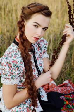 Macar Ulusal Kostüm giymiş genç köylü kadın, doğa arka plan üzerinde poz