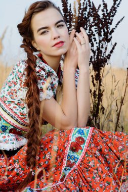 Macar Ulusal Kostüm giymiş genç köylü kadın, doğa arka plan üzerinde poz