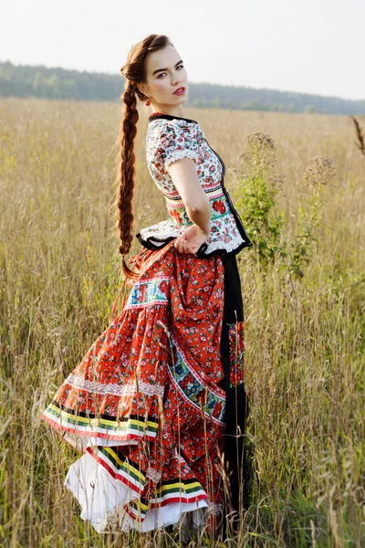 Jovem camponesa, vestida com traje nacional húngaro, posando sobre o fundo da natureza — Fotografia de Stock