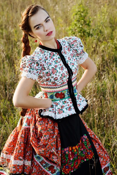 Unga bonden kvinna, klädd i ungerska nationella dräkt, poserar över natur bakgrund — Stockfoto