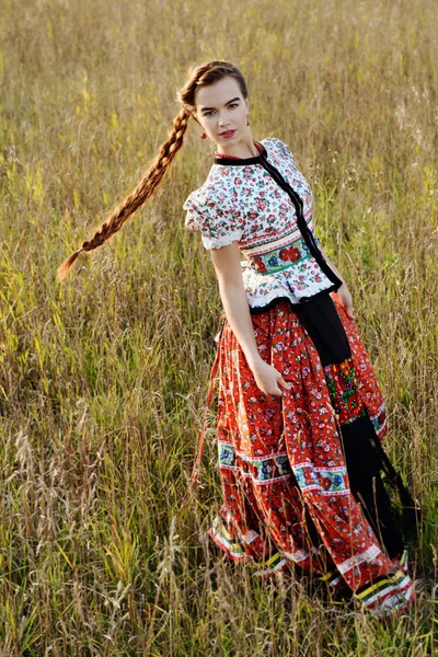 Giovane donna contadina, vestita in costume nazionale ungherese, posa su sfondo naturale — Foto Stock