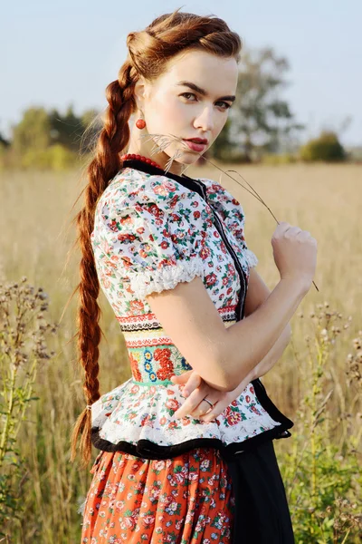 Young peasant woman, dressed in Hungarian national costume, posing over nature background — Stock Photo, Image