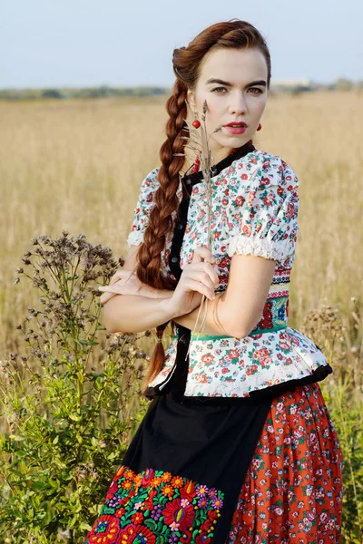 Νεαρή γυναίκα, ντυμένη με ουγγρική εθνική ενδυμασία, θέτοντας πέρα από το υπόβαθρο της φύσης — Φωτογραφία Αρχείου