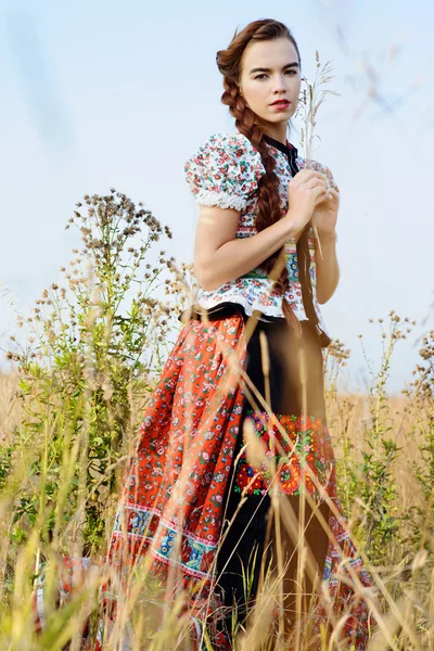 Macar Ulusal Kostüm giymiş genç köylü kadın, doğa arka plan üzerinde poz