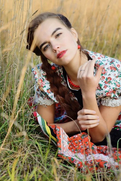 Giovane donna contadina, vestita in costume nazionale ungherese, posa su sfondo naturale — Foto Stock