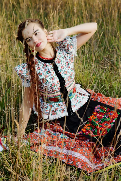 Молодая крестьянка в венгерском национальном костюме позирует на фоне природы — стоковое фото