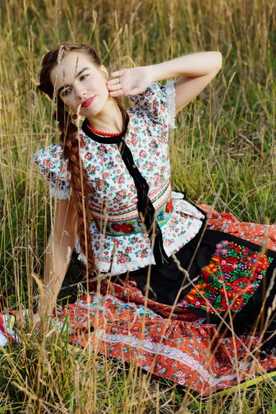 Young peasant woman, dressed in Hungarian national costume, posing over nature background — Stock Photo, Image