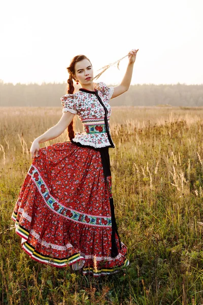 Fiatal parasztasszony, öltözve magyar népviselet, pózol, mint háttér természet — Stock Fotó