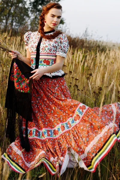 Unga bonden kvinna, klädd i ungerska nationella dräkt, poserar över natur bakgrund — Stockfoto