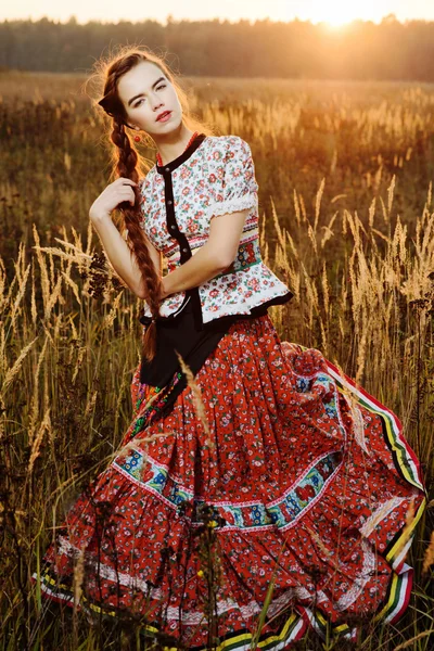 Macar Ulusal Kostüm giymiş genç köylü kadın, doğa arka plan üzerinde poz