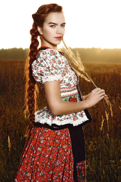 Молодая крестьянка в венгерском национальном костюме позирует на фоне природы — стоковое фото