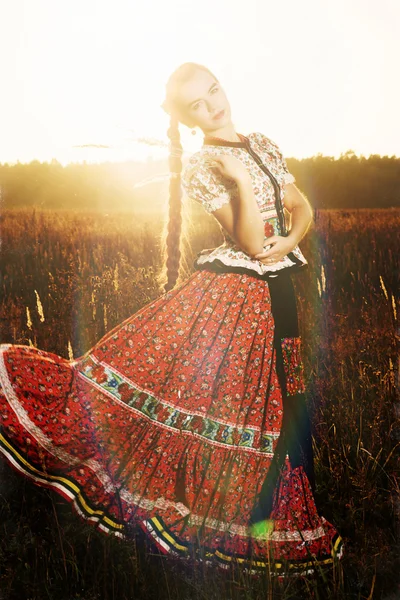 Young peasant woman, dressed in Hungarian national costume, posing over nature background — Stock Photo, Image