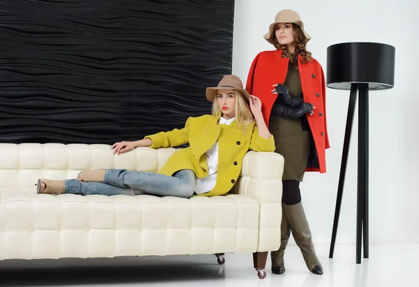 Meninas em estúdio posando em casacos — Fotografia de Stock