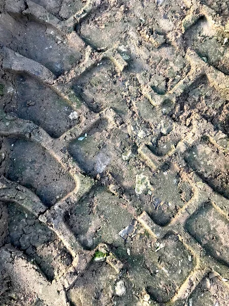 Tinted photo of footprints in the sand, earth, dirt from tire treads, car wheels. Industrial, construction, heavy machinery, dump trucks, trucks, tractors, loaders