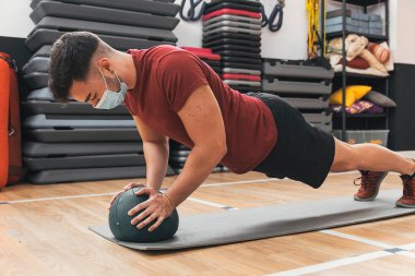 Çocuk spor salonunda topla egzersiz yapıyor.