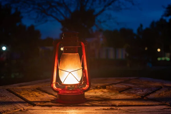 red petrol lamp on old wood table. plain white sheet of paper. autumn background