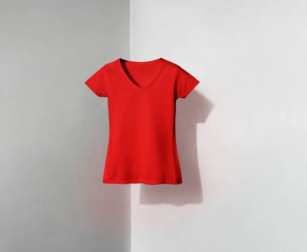 red v-neck shaped t-shirt for women on white and grey background