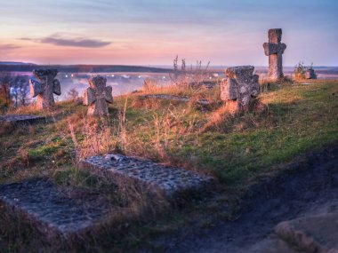 Mezarda alacakaranlık ışığı ve eski mezarlığın haçları.