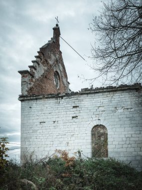 Bulutlu bir günde terk edilmiş kilisenin cephesi ve duvarı