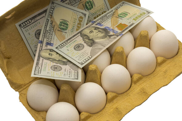 money lies on a package with white chicken eggs