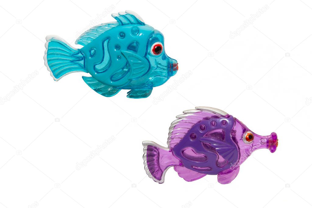 old shabby multicolored fish made of plastic on a white background