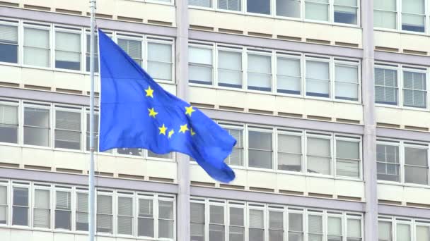 Bandera europea ondeando frente a un edificio gris — Vídeos de Stock