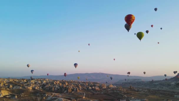 CAPPADOCIA, TURQUÍA - marzo 2021 globos volando en el cielo despejado de la mañana. lapso de tiempo — Vídeo de stock