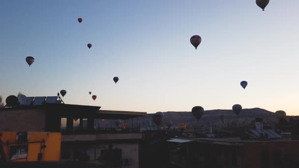 CAPPADOCIA, TURQUÍA - marzo 2021 globos volando en el cielo despejado de la mañana. lapso de tiempo — Vídeo de stock