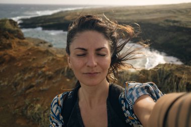 Güzel kız Hawaii 'de güçlü rüzgarla selfie çekiyor. Yüksek kalite fotoğraf