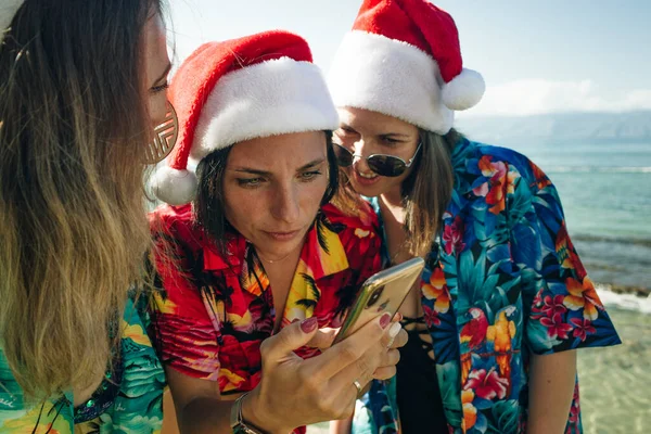 girls in hawaiian shirts sit on the beach at christmas in hawaii. High quality photo