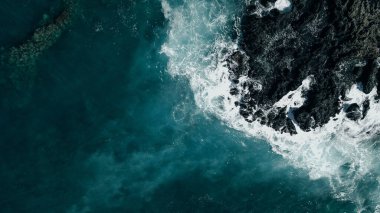 Havadan çekilen dalgalar Hawaii 'deki bir lav kayasına çarpıyor. İHA. Yüksek kalite fotoğraf