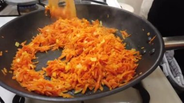 Kızarmış soğanlı büyük bir tavaya ince doğranmış havuç ekle..
