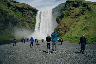 Güney İzlanda 'daki Skogarfoss şelalesinde turistler var. Yüksek kalite fotoğraf