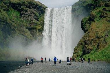 Güney İzlanda 'daki Skogarfoss şelalesinde turistler var. Yüksek kalite fotoğraf