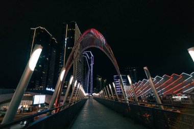 Batumi, Georgia, 7 Ekim 2025. Aydınlatılmış modern binanın su yüzeyine yansıyan gece görüşü. Yüksek kalite fotoğraf