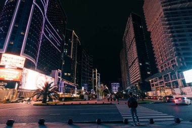 Batumi, Georgia, 7 Ekim 2025. Aydınlatılmış modern binanın su yüzeyine yansıyan gece görüşü. Yüksek kalite fotoğraf