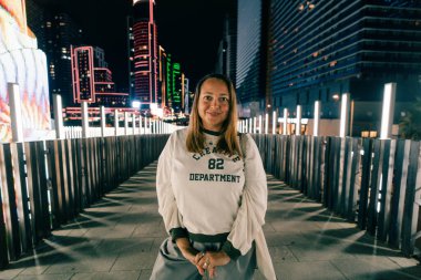 Batumi, Georgia, 7 Ekim 2025. Aydınlatılmış modern binanın su yüzeyine yansıyan gece görüşü. Yüksek kalite fotoğraf