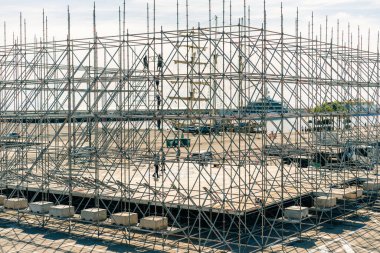 Açık mavi gökyüzüne karşı işçilerin bulunduğu bir inşaat alanında iskele. Yüksek kalite fotoğraf