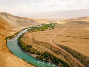 Kırgızistan Kyzyl Oi Köyü 'nün pitoresk manzarasından akan Kokemeren nehri. Arka planda dağlar var. Yüksek kalite fotoğraf