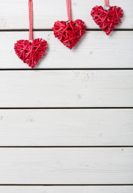 Beyaz ahşap arka planda kırmızı kalpler