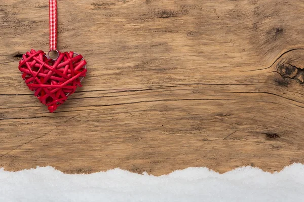 Coração vermelho no fundo de madeira com neve — Fotografia de Stock