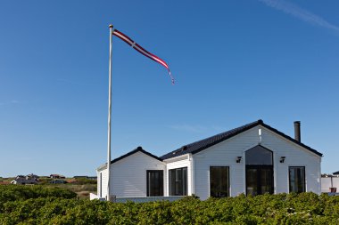 Kumul mavi gökyüzü ve yeşil çim ile geleneksel Danimarka evde