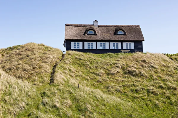 Casa tradicional dinamarquesa na duna de areia com céu azul e grama verde — Fotografia de Stock